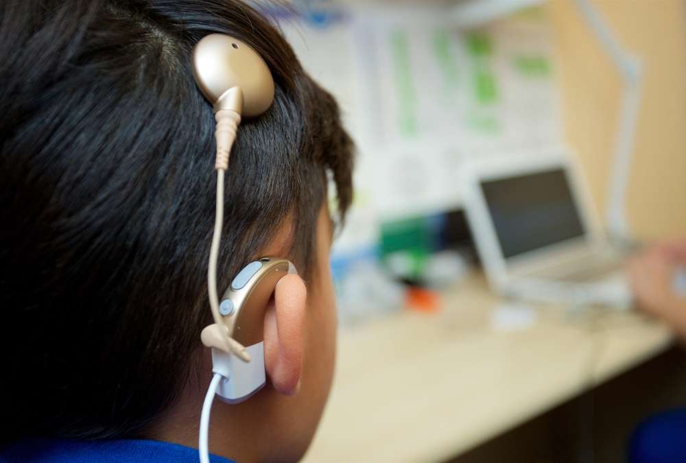This is an image of a boy with a cochlear implant on the head. Contact Better Hearing Center for hearing related issues.